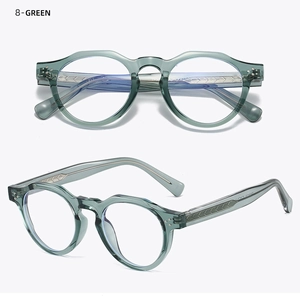 Detail of retro round green glasses frames with translucent finish and metal temple core