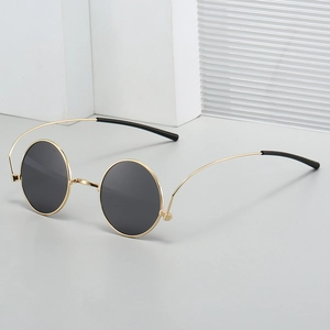 Retro 1960s hippie round gold metal sunglasses with black lenses shown at a 45-degree angle