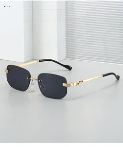 Close-up of golden hollow metal temples and dark lenses on rimless square sunglasses