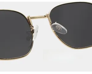 Macro detail of gold metal frame and soft silicone nose pads on square sunglasses