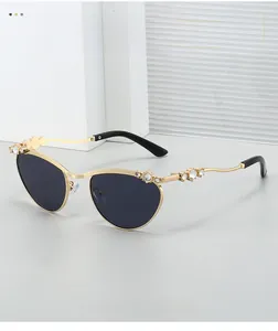 Detailansicht der Cat-Eye Metall-Sonnenbrille mit luxuriösen Strasssteinen auf Stein