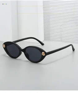 Detail of black oval sunglasses featuring elegant gold rose decorations on the frame edges
