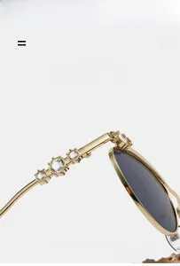 Detailansicht goldener Sonnenbrillenbügel mit luxuriösen Kristallen und dunklen Gläsern