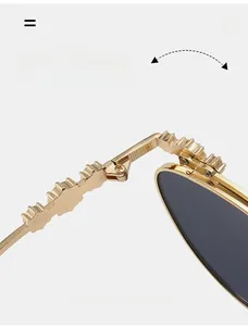 Details des strukturierten Goldmetallscharniers an der luxuriösen Ovalen Sonnenbrille