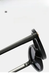 Detail of wide black sunglasses arm with golden embossed medusa head ornament