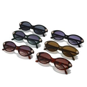 Six pairs of oval frame kids sunglasses with gold rose metal decor on a white background
