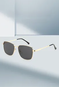 Detail of gold metal frame sunglasses with dark lenses and black temple tips