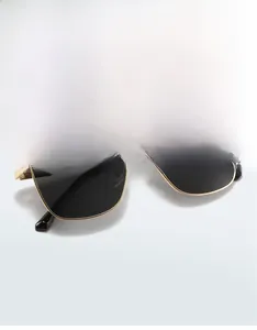 Macro detail of gold metal frame and dark rectangular lenses for trendy men sunglasses