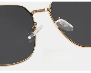 Macro view of gold metal bridge and soft silicone nose pads on oversized sunglasses