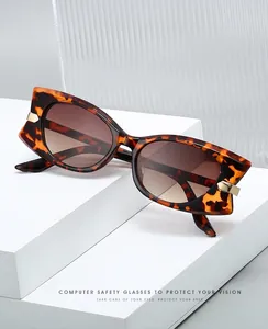 Détail de lunettes de soleil papillon écaillées avec ornements de flèche en métal