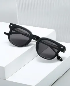 Détail de lunettes carrées noires en TR90 avec rivets flèches et verres teintés