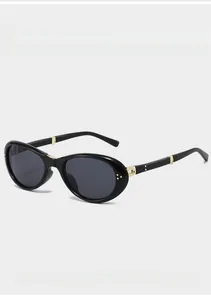 Detail der schwarzen ovalen Falt-Sonnenbrille mit goldenen Metallscharnieren und Design