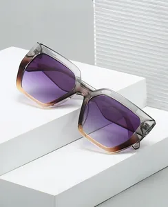 Détail de lunettes de soleil carrées à verres dégradés violets et monture grise élégante