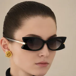 Lunettes de soleil papillon noires avec détails dorés et verres dégradés gris