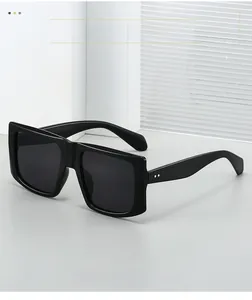 Close-up of black oversized square sunglasses with double dot metal hinge accents