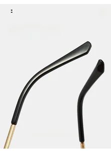 Close-up of black curved mirror legs with gold hinges on vintage sunglasses
