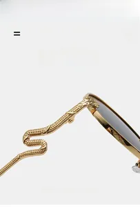 Detail of golden snake-shaped metal temples with scale texture on vintage oval sunglasses