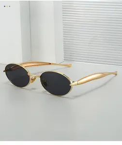 Detail shot of golden oval metal frame sunglasses with wide streamlined temples