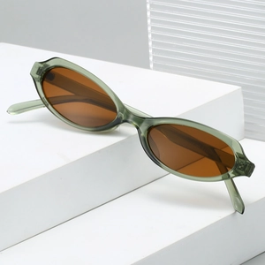 Retro oval sunglasses in translucent olive green with amber lenses on a white platform