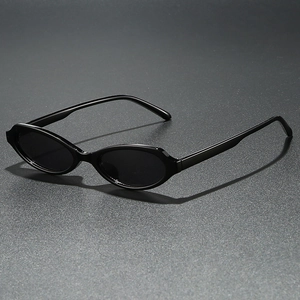 Retro black oval sunglasses with narrow frame and dark lenses on a textured background