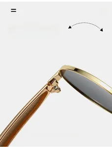 Close-up of durable metal hinge on oval sunglasses with polished gold texture