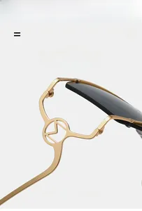 Vue détaillée du logo M évidé sur les branches en alliage doré de ces lunettes chic