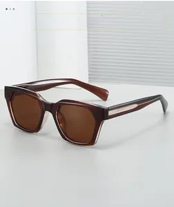 Detail of square amber tortoiseshell sunglasses with brown lenses and metal inlay