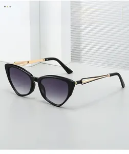Détail des lunettes œil de chat montrant des branches dorées ajourées et verres violets