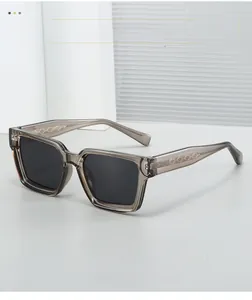 Detail of square sunglasses with translucent grey frame and textured metal inner core