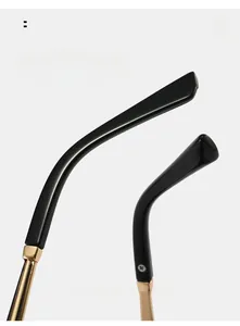 Détail des branches incurvées de lunettes œil de chat, finition noire et charnière dorée