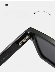 Close-up of the durable metal hinge and specification text on black rectangular sunglasses
