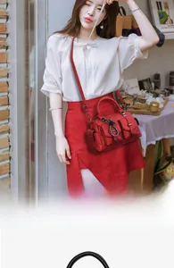Détail du sac bandoulière en cuir rouge avec poche à rabat et boucle fer à cheval
