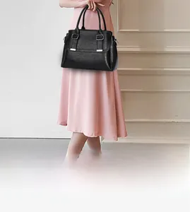 Detail of black pebbled leather tote bag with silver square buckle and flap closure