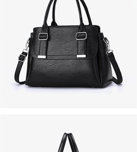 Detail of black textured leather bag with silver buckles and adjustable shoulder strap
