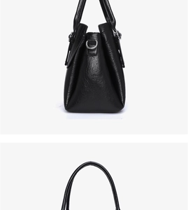 Close-up of black lychee grain leather handbag with silver hardware and D-ring detail