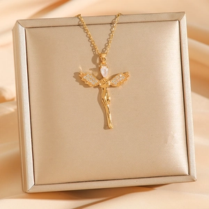 Detailed shot of golden angel pendant with inlaid crystals on a silk luxury background