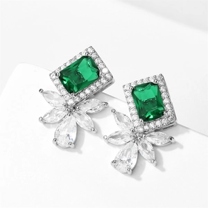 Detail of emerald green rectangular zircon earring with sparkling cluster diamonds