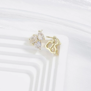 Detailed close-up of heart and pear-cut zircon earrings in a gold-plated setting