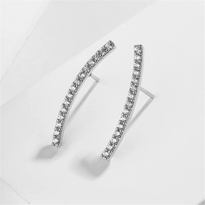 Macro detail of silver curved stud earrings featuring cubic zirconia and pearl inlay