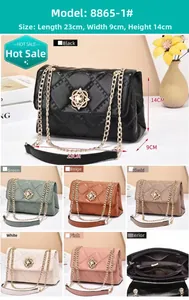 Close-up of quilted leather crossbody bag with flower-shaped gold lock and metal chain
