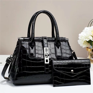Polished black crocodile embossed tote bag with matching envelope pouch on white desk