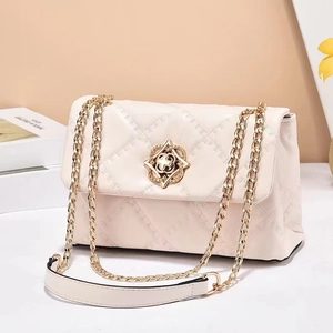 Chic cream quilted crossbody bag with golden chain strap and floral geometric lock