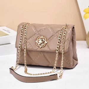 Elegant quilted crossbody bag with gold floral buckle and chain strap in cocoa beige