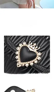 Detail of black quilted leather bag featuring a gold heart crown lock and radial stitching