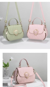 Detail of shell-shaped bags with wavy quilting and heart crown metal buckle