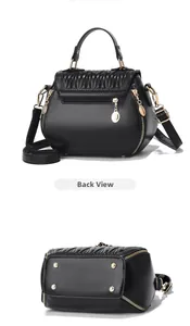 Detail view of black shell bag showing back zipper pocket and golden hardware feet
