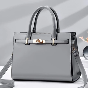 Détail du sac à main en cuir verni gris brillant avec fermoir rotatif doré