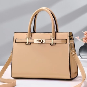 Détail du sac à main en cuir verni beige avec fermoir en métal et bandoulière amovible