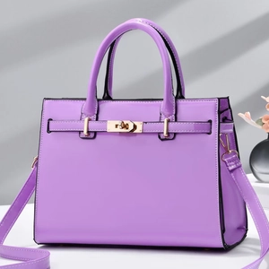 Détail du sac à main en cuir verni violet avec ferrures dorées et picots de protection