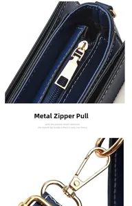 Macro view of gold-tone zipper pull and strap hook on navy blue leather handbag